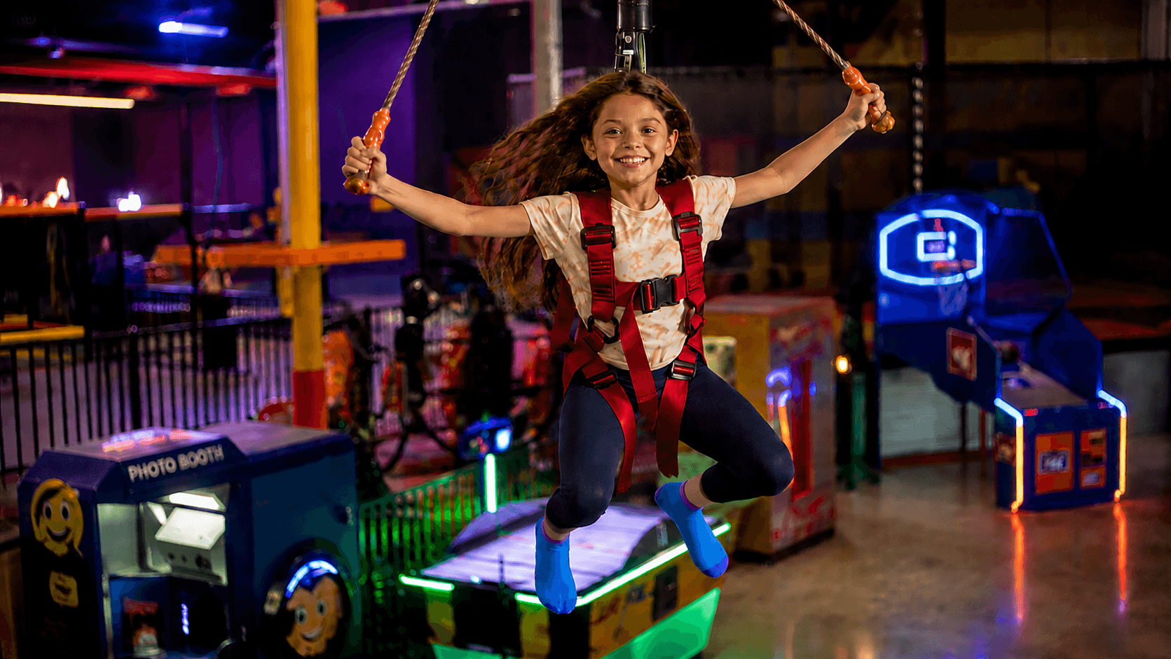 Child soaring on a bungee swing at an indoor adventure park